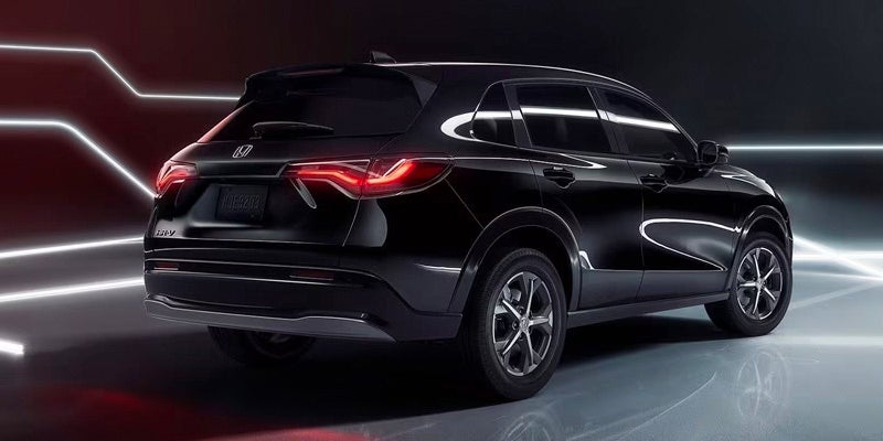 An all-new Crystal Black Pearl 2024 Honda HR-V parked in a futuristic light setting in Oxford, NC.