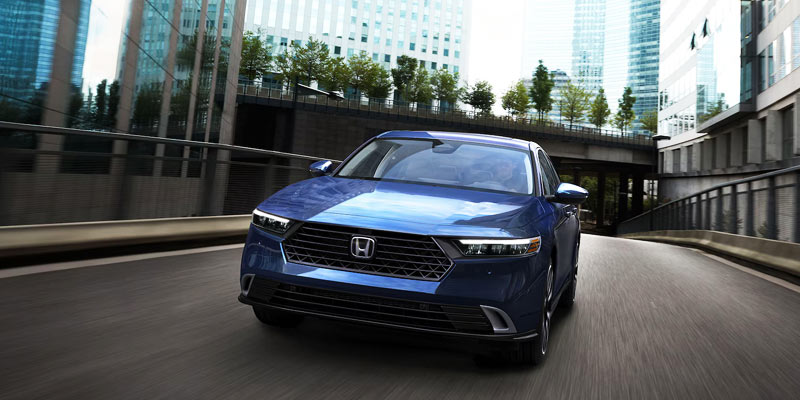 An all-new blue 2025 Honda Accord Sedan driving through downtown streets. - Boyd Honda Oxford, NC