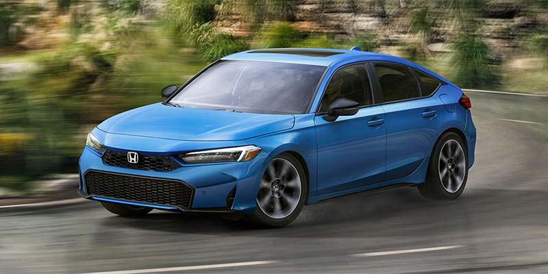 A blue Honda Civic Hatchback driving on a winding road