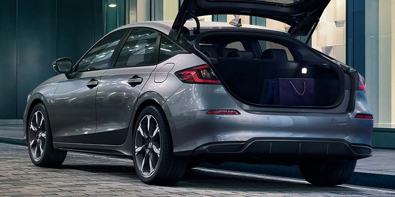 A silver Honda Civic Hatchback parked with its open trunk