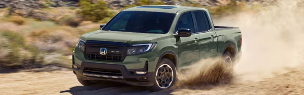Green Honda Ridgeline driving on a dirt road.