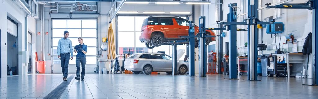 Automotive service center with technicians reviewing vehicle maintenance in a workshop
